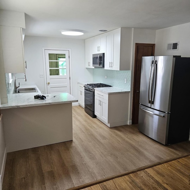 5823 W Addison St, Chicago, IL 60634 - kitchen with stainless steel appliances, light stone countertops, light wood finished floors, and white cabinetry