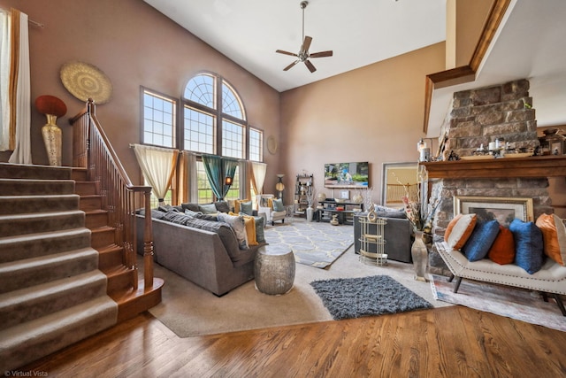26200 W Chatham Dr, Plainfield, IL 60585 - living room featuring high vaulted ceiling, a ceiling fan, wood finished floors, stairway, and a stone fireplace