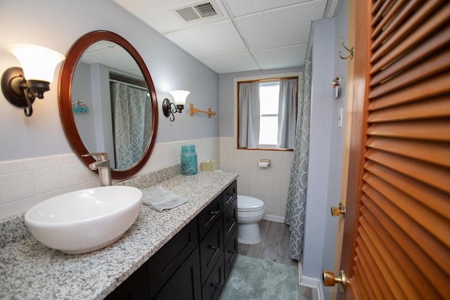 5518 S Melvina Ave, Chicago, IL 60638 - full bathroom with tile walls, a paneled ceiling, vanity, wainscoting, and wood finished floors