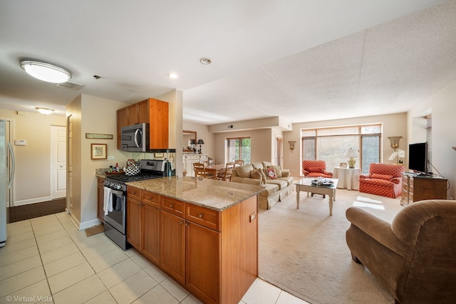 865 E 22nd St Unit 214, Lombard, IL 60148 - kitchen featuring stainless steel appliances, open floor plan, brown cabinets, and light tile patterned floors
