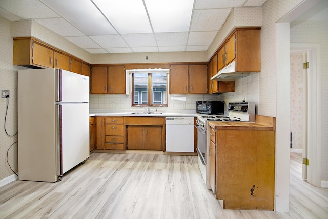 866 S Evergreen Ave, Kankakee, IL 60901 - kitchen featuring white appliances, under cabinet range hood, brown cabinets, light wood-style floors, and wallpapered walls