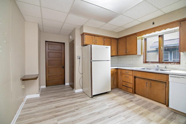 866 S Evergreen Ave, Kankakee, IL 60901 - kitchen featuring white appliances, light wood finished floors, a drop ceiling, brown cabinets, and light countertops