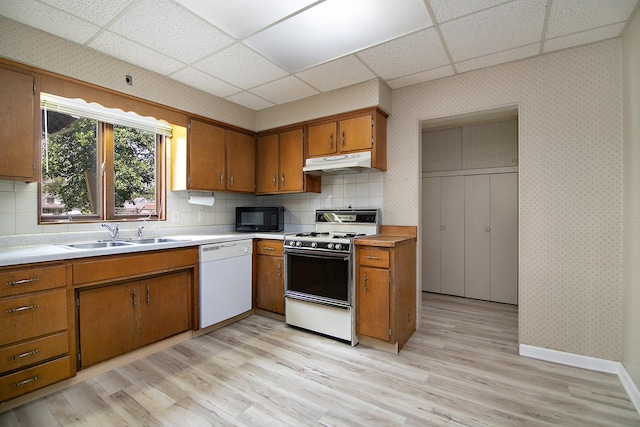 866 S Evergreen Ave, Kankakee, IL 60901 - kitchen with white appliances, a drop ceiling, under cabinet range hood, brown cabinetry, and light wood-type flooring