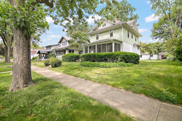 866 S Evergreen Ave, Kankakee, IL 60901 - view of front facade with a front yard, a chimney, and a sunroom