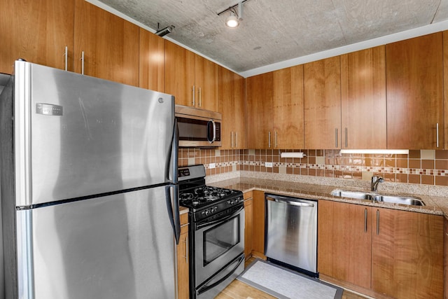 611 S Wells St Unit 1304, Chicago, IL 60607 - kitchen with stainless steel appliances, brown cabinets, backsplash, light stone counters, and light wood-style flooring