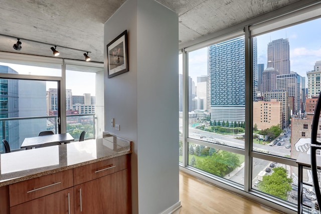 611 S Wells St Unit 1304, Chicago, IL 60607 - kitchen with a skyline view, track lighting, light wood-type flooring, light stone counters, and floor to ceiling windows