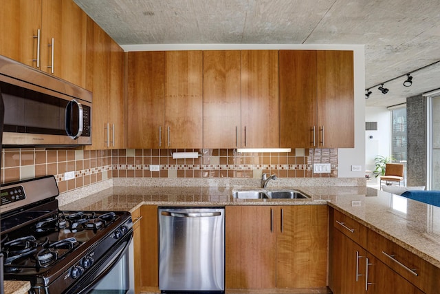 611 S Wells St Unit 1304, Chicago, IL 60607 - kitchen with stainless steel appliances, brown cabinets, track lighting, and decorative backsplash
