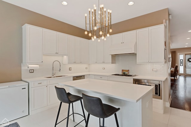 1807 W Ohio St, Chicago, IL 60622 - kitchen featuring custom range hood, appliances with stainless steel finishes, light countertops, a kitchen island, and backsplash