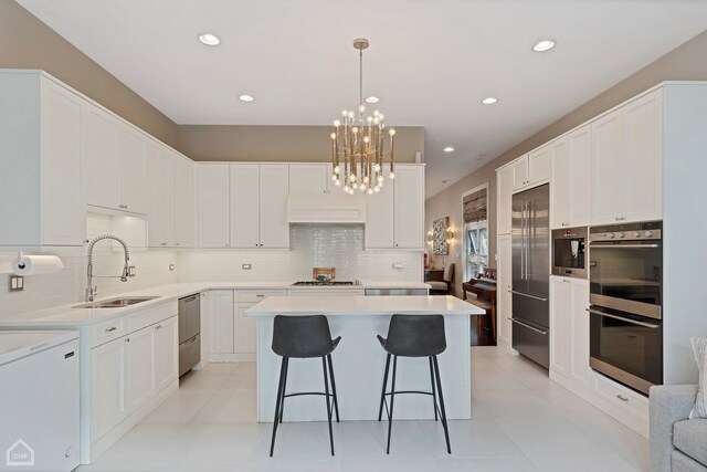 1807 W Ohio St, Chicago, IL 60622 - kitchen featuring appliances with stainless steel finishes, a chandelier, a kitchen island, tasteful backsplash, and recessed lighting