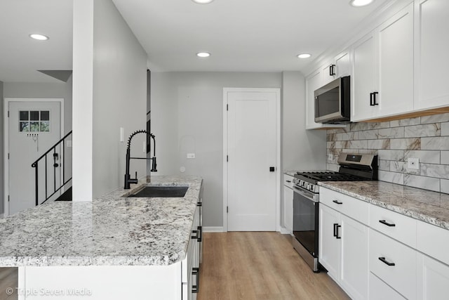 10 Cour Masson Unit 10, Palos Hills, IL 60465 - kitchen with appliances with stainless steel finishes, light wood finished floors, recessed lighting, white cabinets, and decorative backsplash