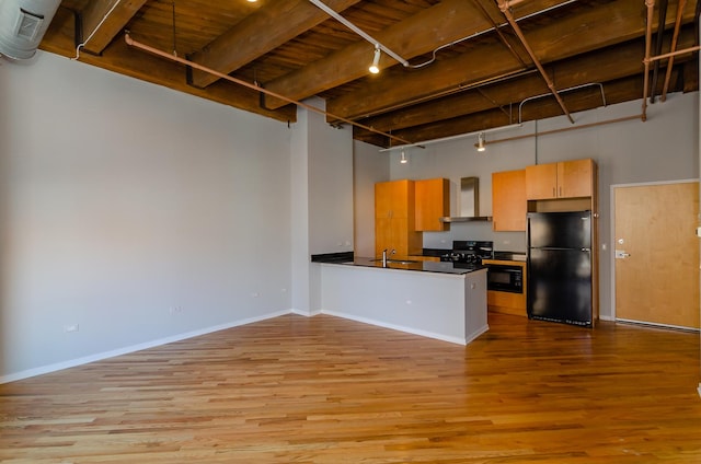 1040 W Adams St Unit 257, Chicago, IL 60607 - kitchen featuring freestanding refrigerator, wall chimney range hood, rail lighting, stove, and light wood finished floors