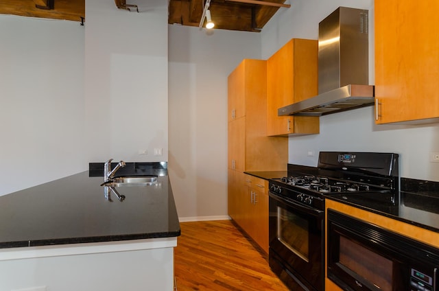 1040 W Adams St Unit 257, Chicago, IL 60607 - kitchen with black appliances, wall chimney range hood, dark countertops, wood finished floors, and a peninsula