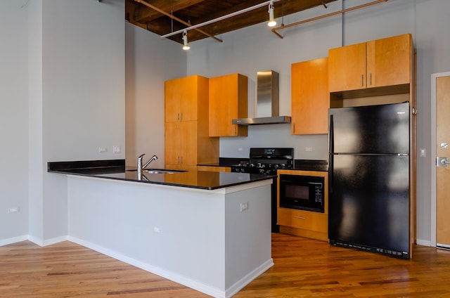 1040 W Adams St Unit 257, Chicago, IL 60607 - kitchen with black appliances, wall chimney exhaust hood, a towering ceiling, dark countertops, and rail lighting
