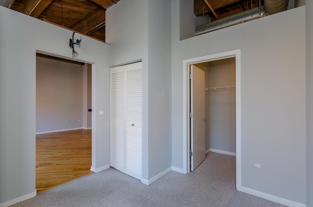 1040 W Adams St Unit 257, Chicago, IL 60607 - unfurnished bedroom featuring carpet flooring, a high ceiling, a wood ceiling with exposed beams, and a closet
