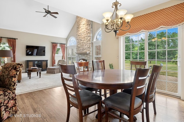605 Red Cypress Dr, Cary, IL 60013 - dining space featuring high vaulted ceiling, a fireplace, light wood finished floors, a ceiling fan, and a chandelier