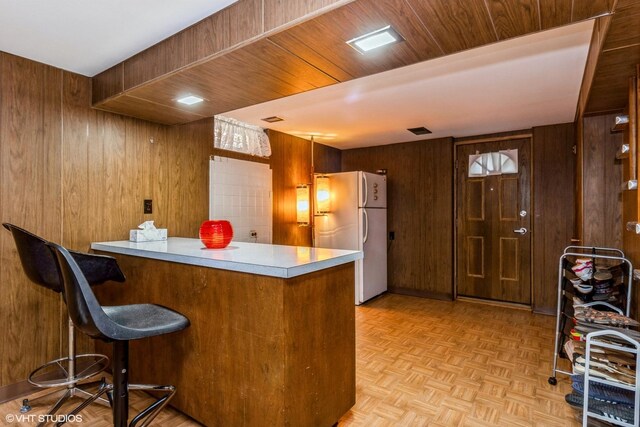 5705 N Oketo Ave, Chicago, IL 60631 - kitchen featuring freestanding refrigerator, wooden walls, a peninsula, light countertops, and brown cabinets