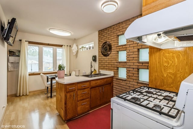 5705 N Oketo Ave, Chicago, IL 60631 - kitchen featuring ventilation hood, brick wall, brown cabinets, light wood finished floors, and white gas stove