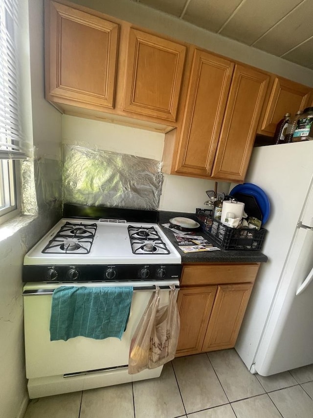 6827 N Oakley Ave Unit 3C, Chicago, IL 60645 - kitchen with white appliances, light tile patterned flooring, brown cabinets, and dark countertops
