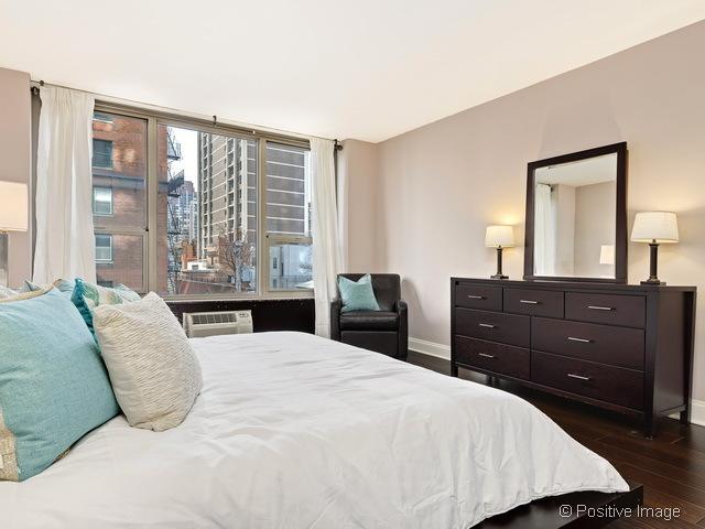 1550 N Lake Shore Dr Unit 3G, Chicago, IL 60610 - bedroom with dark wood-style flooring and a wall unit AC