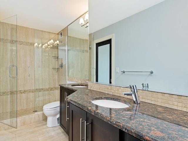 1550 N Lake Shore Dr Unit 3G, Chicago, IL 60610 - bathroom featuring vanity, a stall shower, and decorative backsplash