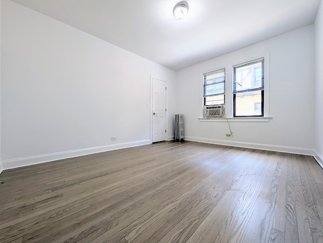 5655 N Spaulding Ave Unit 2W, Chicago, IL 60659 - empty room with dark wood-style floors, radiator, and cooling unit