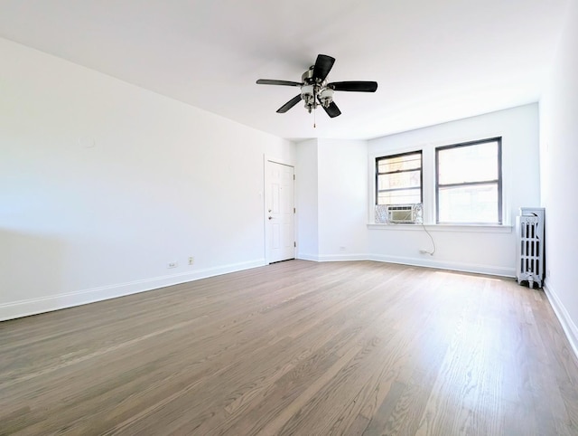 5655 N Spaulding Ave Unit 2W, Chicago, IL 60659 - unfurnished room featuring radiator, wood finished floors, cooling unit, and ceiling fan