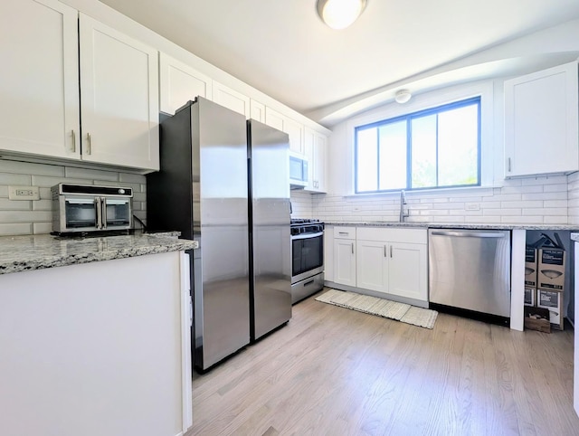 5655 N Spaulding Ave Unit 2W, Chicago, IL 60659 - kitchen with appliances with stainless steel finishes, decorative backsplash, white cabinets, light wood-type flooring, and lofted ceiling