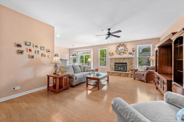 2519 Imgrund Rd, North Aurora, IL 60542 - living room with a ceiling fan, light wood-style flooring, and a stone fireplace