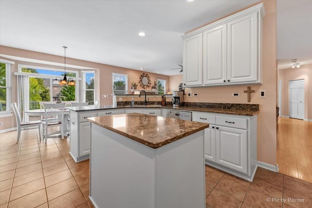 2519 Imgrund Rd, North Aurora, IL 60542 - kitchen with a peninsula, white cabinets, a kitchen island, recessed lighting, and dark stone countertops