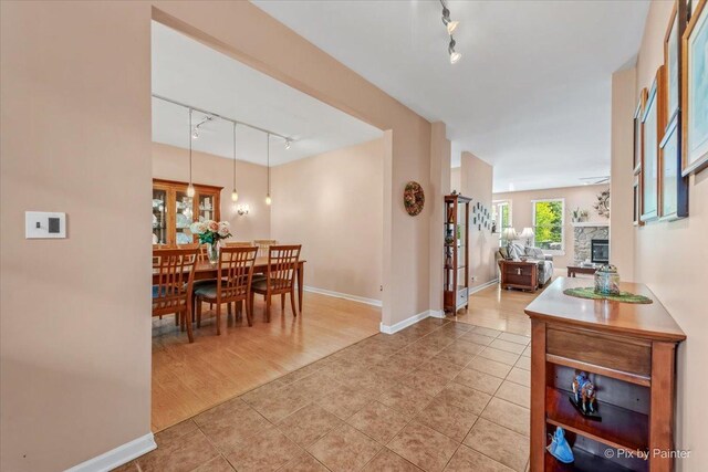 2519 Imgrund Rd, North Aurora, IL 60542 - dining room with rail lighting, light tile patterned flooring, and a fireplace