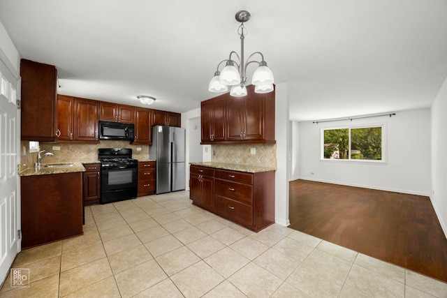 728 Boxwood Dr, Schaumburg, IL 60193 - kitchen with black appliances, backsplash, a chandelier, light stone counters, and light tile patterned floors