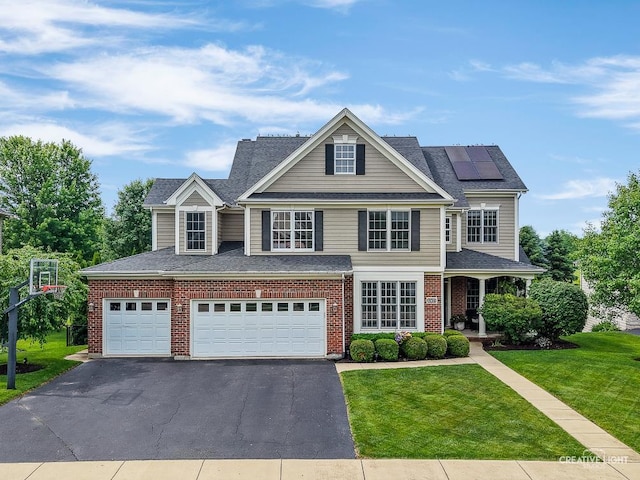 40W379 E Laura Ingalls Wilder Rd, Saint Charles, IL 60175 - traditional home with a front lawn, asphalt driveway, solar panels, brick siding, and covered porch