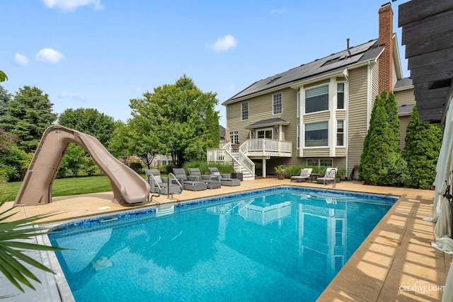 40W379 E Laura Ingalls Wilder Rd, Saint Charles, IL 60175 - swimming pool with a water slide, stairway, a wooden deck, and a patio area