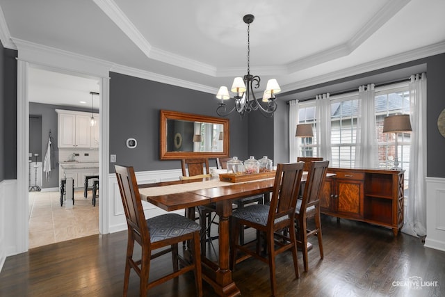 40W379 E Laura Ingalls Wilder Rd, Saint Charles, IL 60175 - dining space featuring a chandelier, a wainscoted wall, dark wood-type flooring, a tray ceiling, and crown molding