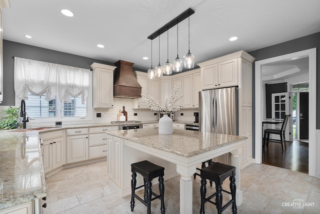 40W379 E Laura Ingalls Wilder Rd, Saint Charles, IL 60175 - kitchen with custom exhaust hood, light stone countertops, decorative backsplash, a center island, and recessed lighting