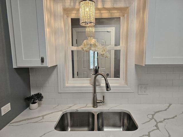 12136 S Wentworth Ave, Chicago, IL 60628 - kitchen featuring a chandelier, white cabinets, decorative backsplash, and light stone countertops