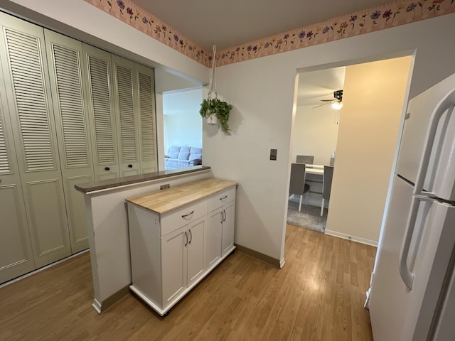 900 E Wilmette Rd Unit 411, Palatine, IL 60074 - kitchen with light wood finished floors, a ceiling fan, white cabinetry, freestanding refrigerator, and a peninsula