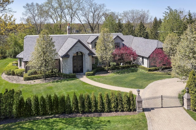 1630 Ridge Rd, Highland Park, IL 60035 - tudor-style house with a gate, stone siding, and a front yard