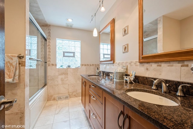 4841 W Lunt Ave, Lincolnwood, IL 60712 - full bathroom with tile walls, double vanity, bath / shower combo with glass door, and wainscoting