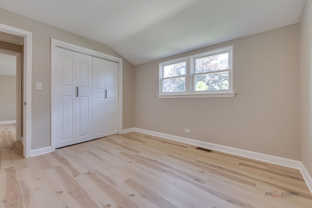 4021 W Estes Ave, Lincolnwood, IL 60712 - unfurnished bedroom with vaulted ceiling, light wood finished floors, and a closet
