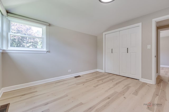 4021 W Estes Ave, Lincolnwood, IL 60712 - unfurnished bedroom with light wood-style flooring, lofted ceiling, and a closet