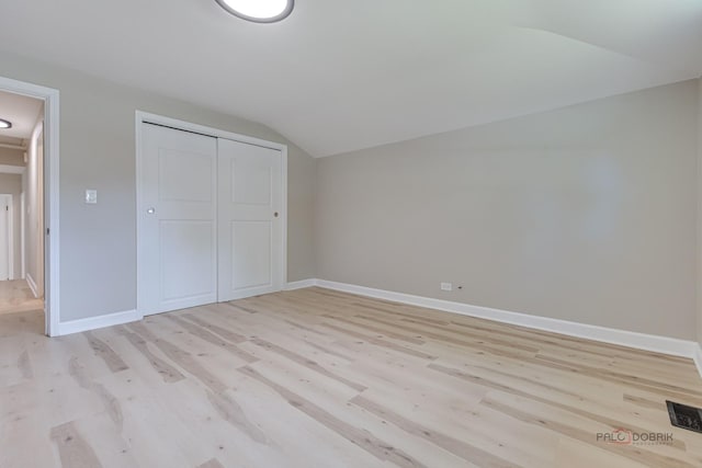 4021 W Estes Ave, Lincolnwood, IL 60712 - unfurnished bedroom with lofted ceiling, light wood-style flooring, and a closet