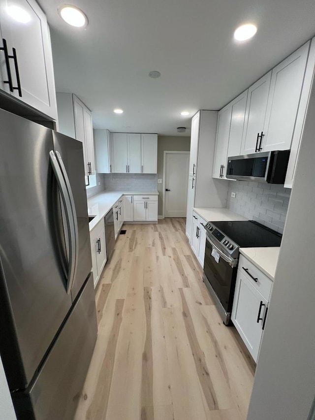 4021 W Estes Ave, Lincolnwood, IL 60712 - kitchen with appliances with stainless steel finishes, light wood-style floors, white cabinets, decorative backsplash, and recessed lighting