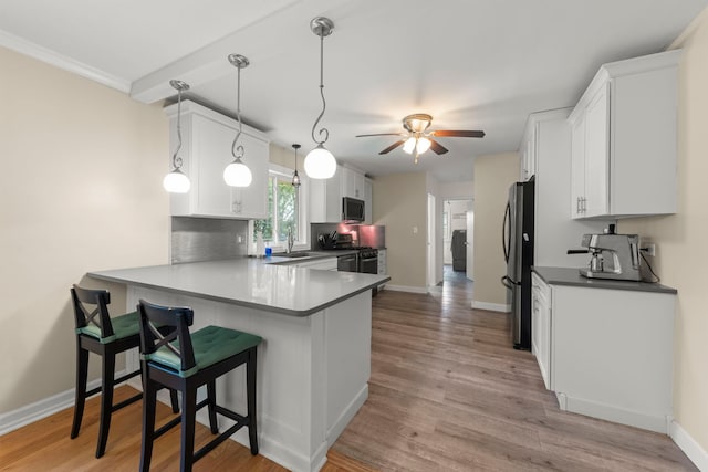 2839 School St, Flossmoor, IL 60422 - kitchen with appliances with stainless steel finishes, a peninsula, white cabinets, ceiling fan, and a kitchen bar