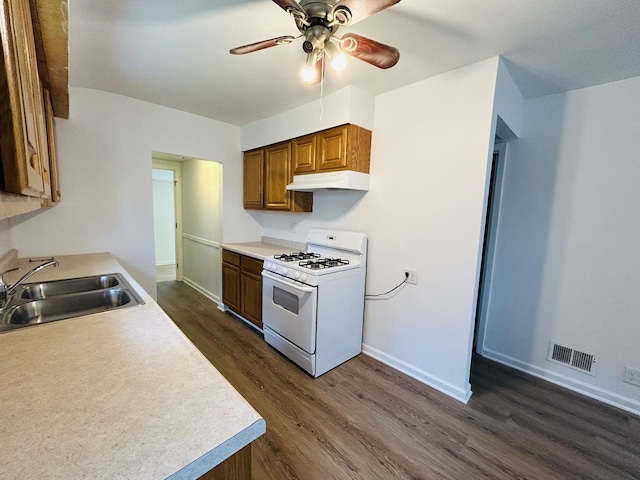 37706 N Nippersink Pl, Spring Grove, IL 60081 - kitchen with white gas stove, under cabinet range hood, dark wood finished floors, a ceiling fan, and light countertops