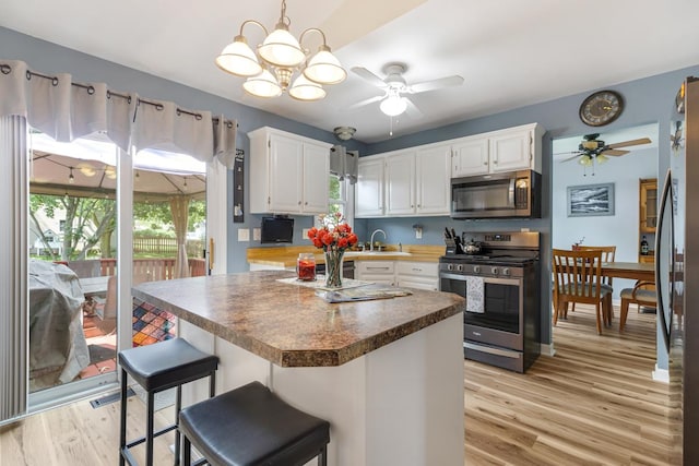 1234 Hillsboro Dr, Batavia, IL 60510 - kitchen featuring appliances with stainless steel finishes, a ceiling fan, light wood-style floors, and white cabinets