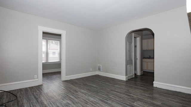 312 N Mclean St, Bloomington, IL 61701 - unfurnished room with dark wood finished floors and arched walkways