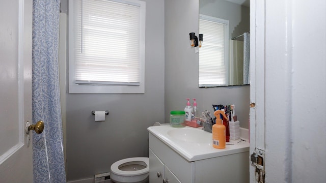 312 N Mclean St, Bloomington, IL 61701 - bathroom featuring vanity, plenty of natural light, baseboard heating, and a shower with curtain