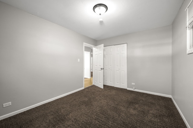 1055 N Bluebonnet Ln, Hoffman Estates, IL 60169 - unfurnished bedroom featuring dark colored carpet and a closet