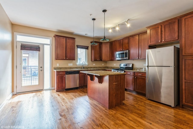 1240 W Monroe St Unit 7, Chicago, IL 60607 - kitchen with appliances with stainless steel finishes, dark wood-style floors, a kitchen island, a kitchen breakfast bar, and pendant lighting